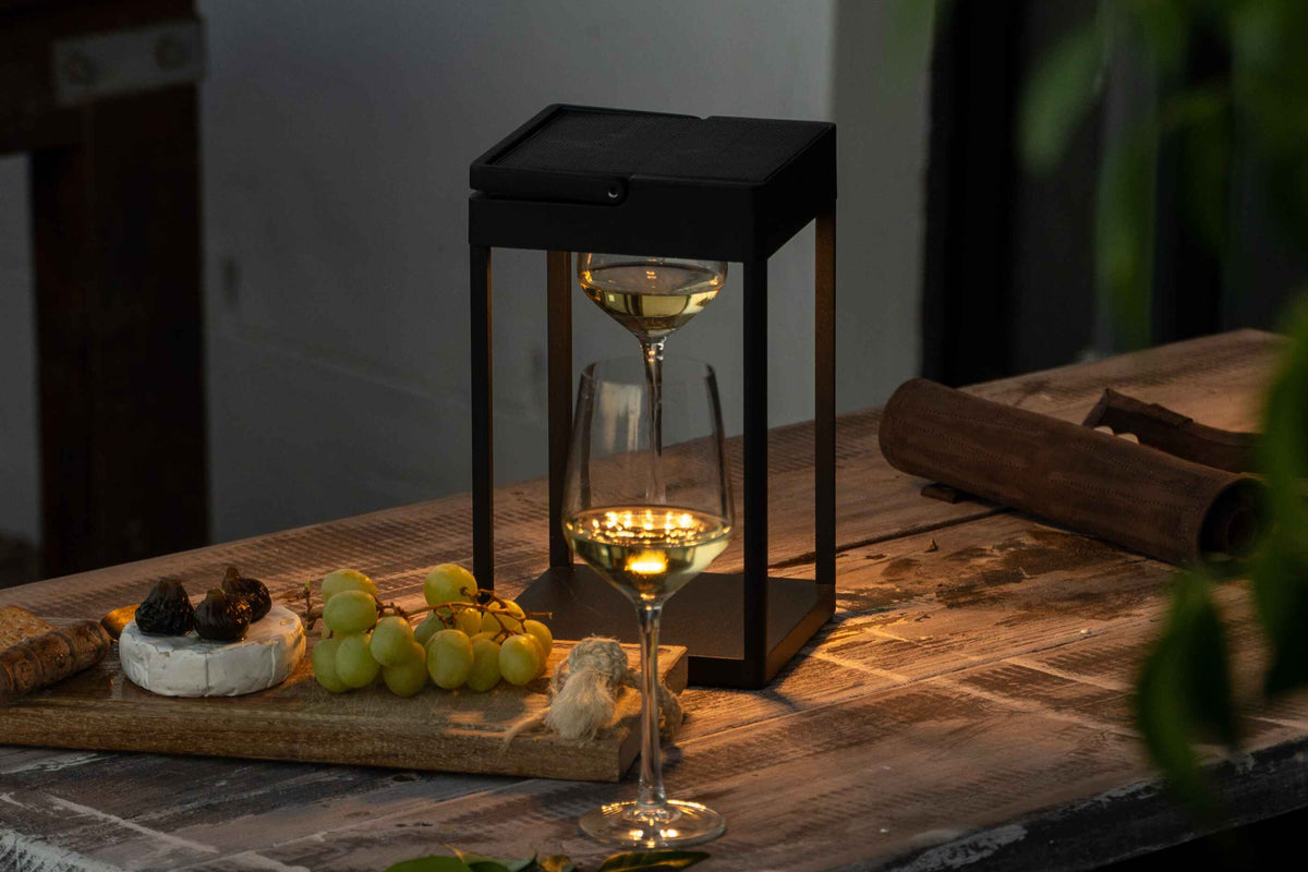 wine glass under a black lantern on a table 