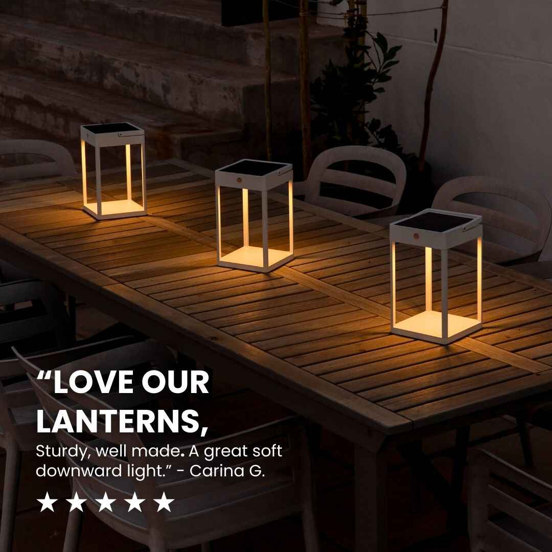 Lanterne a energia solare su un tavolo di legno in un ambiente poco illuminato.